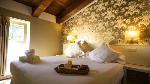 聖馬丁德瓦德格萊西亞斯的住宿－拉克拉賽拉莊園酒店，一间卧室配有一张床,上面放着一个食物托盘