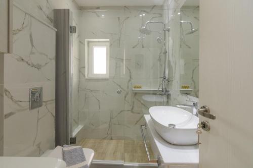 bagno bianco con lavandino e doccia di One Bedroom Apt w/ Balcony ad Atene