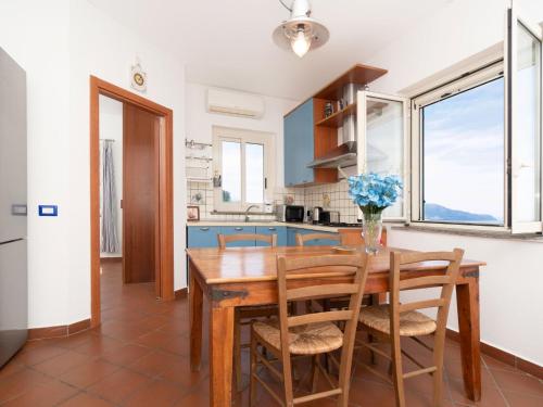 kuchnia i jadalnia z drewnianym stołem i krzesłami w obiekcie Holiday Home Baldassarre by Interhome w mieście Termini