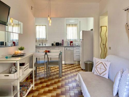 cocina y sala de estar con mesa y nevera en Apartment Aquarius by Interhome, en Tossa de Mar