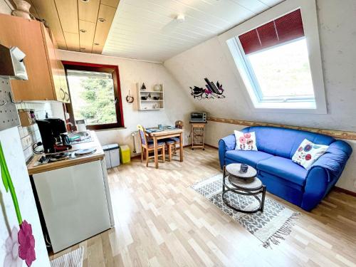 sala de estar con sofá azul y cocina en Apartment Gebauer-1 by Interhome, en Fuchshofen