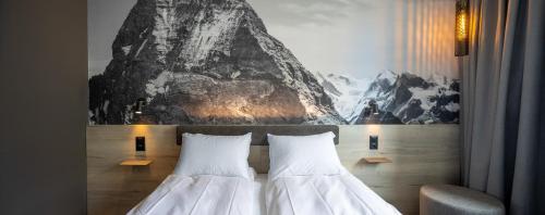 two beds in a hotel room with a painting on the wall at Zleep Hotel Lausanne-Chavannes NEW OPENING in Lausanne