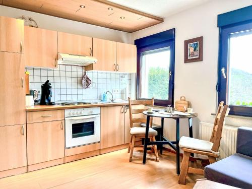 a kitchen with wooden cabinets and a table with chairs at Apartment Gebauer-2 by Interhome in Fuchshofen