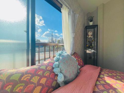 a bedroom with a stuffed animal on a bed next to a window at 尹府F栋 天空树景观 in Tokyo