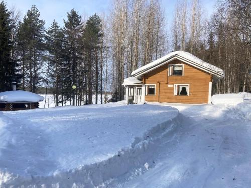 een huis met een berg sneeuw ervoor bij Holiday Home Haapala by Interhome in Karjalaisenniemi