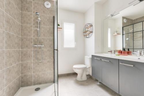 a bathroom with a shower and a toilet and a sink at Séjour ressourçant dans cette jolie maison in Andernos-les-Bains