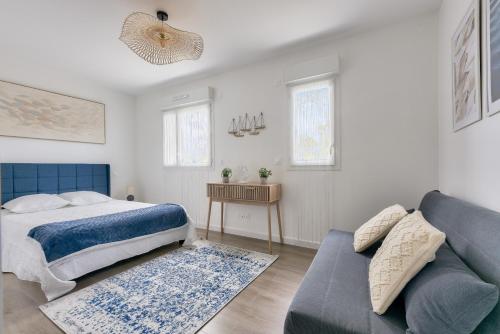 une chambre avec un lit et un canapé dans l'établissement Jolie maison avec terrasse à Andernos-les-bains, à Andernos-les-Bains