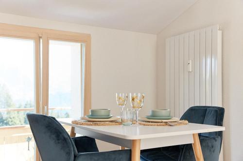 a dining room with a white table and chairs at Gantrisch Lodge Ottenleuebad in Guggisberg