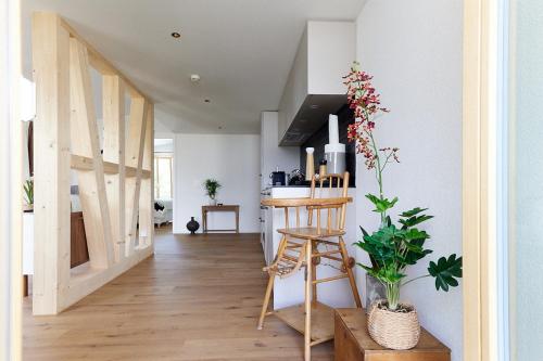 a living room with a staircase and a kitchen with a counter at Gantrisch Lodge Ottenleuebad in Guggisberg