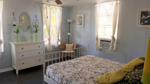 a bedroom with a bed and a dresser and windows at Barra Villa Resort House I in Fort Myers