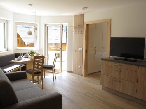 a living room with a couch and a table with a television at Apartment Spieglhof-1 by Interhome in Sarntal