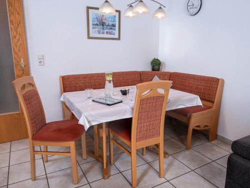 een eettafel met stoelen en een wit tafelkleed bij Apartment Kluntje by Interhome in Norddeich