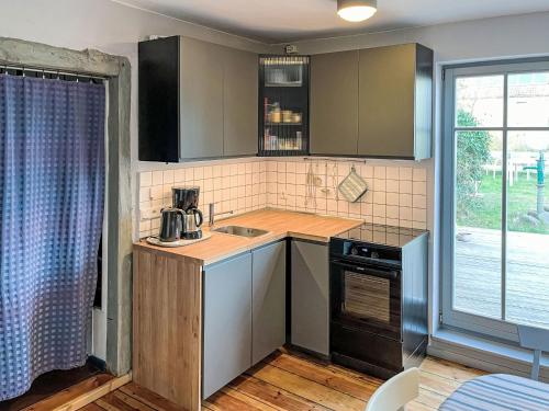 a small kitchen with a sink and a stove at Holiday Home Kapitänshaus Leo by Interhome in Leopoldshagen