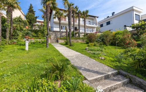 einen Garten mit Palmen und ein Gebäude in der Unterkunft Nice Apartment In Opatija With Wi-fi in Opatija