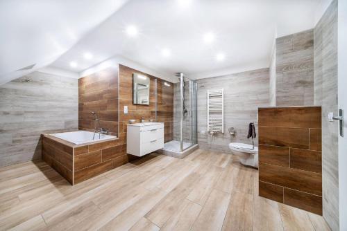 een badkamer met een bad, een wastafel en een toilet bij Pension Delicato in Waidhaus