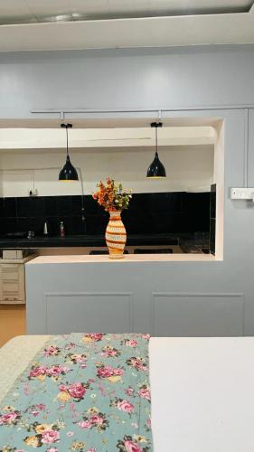a kitchen with a vase of flowers on a counter at Janki Kunj Varanasi- 3 Room Home in Varanasi