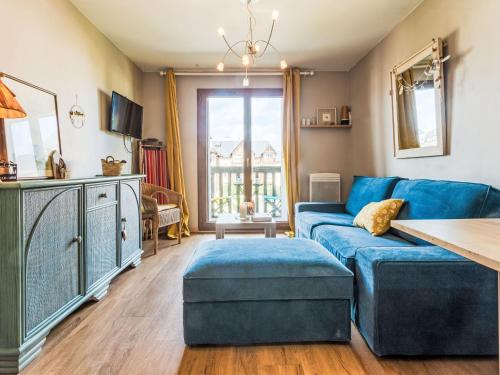 a living room with a blue couch and a table at Apartment Le Clos Mathilde-18 by Interhome in Cabourg