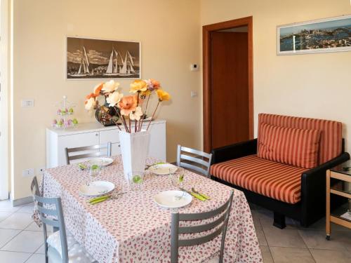 una sala da pranzo con tavolo e vaso di fiori di Apartment Roseto by Interhome a Cervo