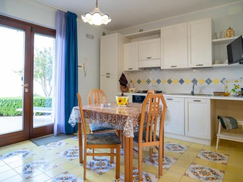 eine Küche mit einem Tisch und Stühlen sowie eine Küche mit weißen Schränken in der Unterkunft Apartment Girasole by Interhome in Termoli