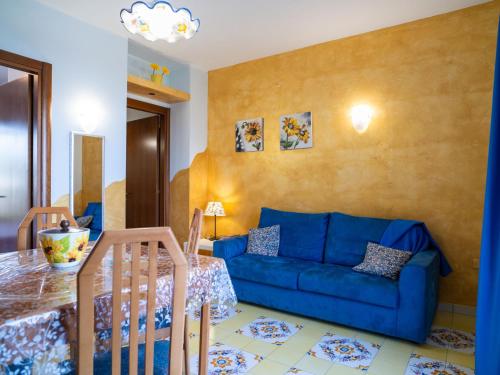 ein Wohnzimmer mit einem blauen Sofa und einem Tisch in der Unterkunft Apartment Girasole by Interhome in Termoli