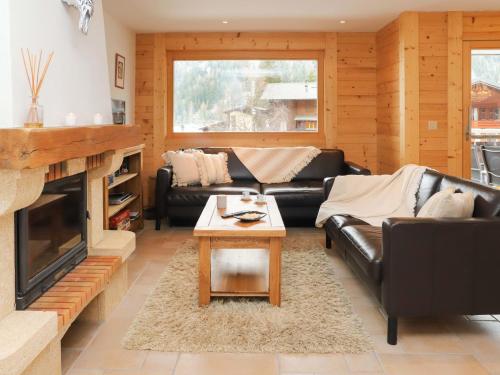ein Wohnzimmer mit schwarzen Ledermöbeln und einem Kamin in der Unterkunft Apartment Les Mayens 1-1 by Interhome in Champex