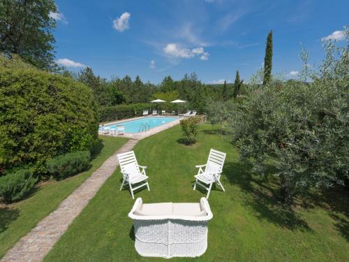 a yard with chairs and a swimming pool at Holiday Home Villa del Poggio by Interhome in Radda in Chianti