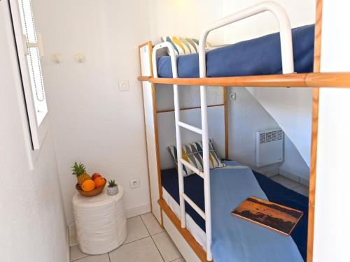 Ce lit superposé se trouve dans un dortoir doté d'un escalier bleu. dans l'établissement Apartment Le Village - C0363 by Interhome, à Agay