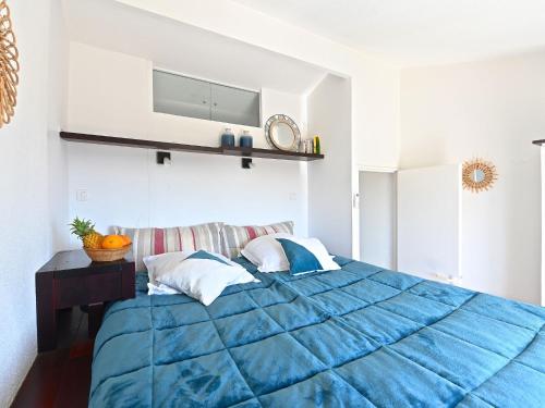 - une chambre avec une couette bleue sur un lit dans l'établissement Apartment Le Village - C0363 by Interhome, à Agay