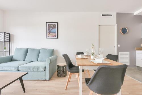un salon avec un canapé bleu et une table dans l'établissement À 500m de la plage de la Jetée, appartement pour 4, à Andernos-les-Bains
