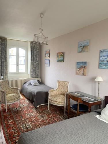 - une chambre avec un lit, une table et des chaises dans l'établissement Villa Hébert, à Saint-Malo