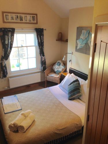 a bedroom with a bed with towels on it at Bridge View Guest House in Ironbridge