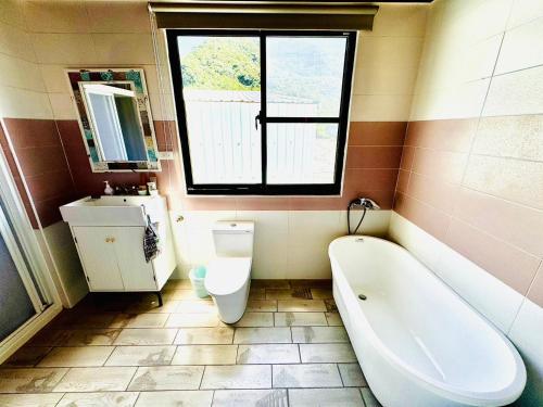 a bathroom with a tub and a toilet and a sink at 綠島寧靜海潛水-城堡館 Twinkleocean diving hostel in Green Island