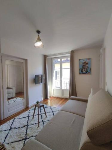 un salon avec un canapé et un miroir dans l'établissement Studio en duo centre de Thonon, à Thonon-les-Bains