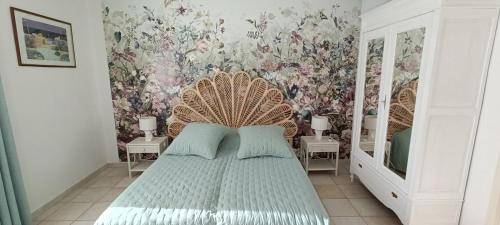 a bedroom with a bed with a floral wallpaper at VILLA HIBISCUS in Callian