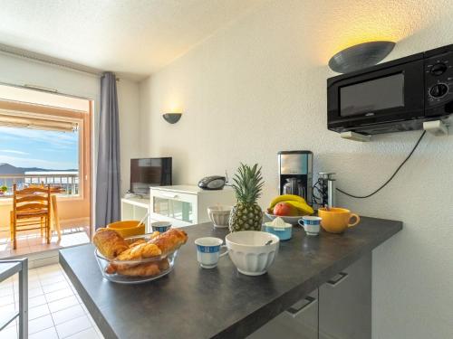 - une cuisine avec une table, du pain et des fruits dans l'établissement Apartment Les Morières-4 by Interhome, à Six-Fours-les-Plages