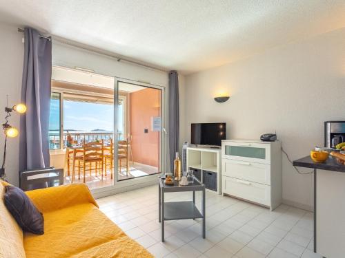 Il comprend un salon avec un canapé et une cuisine avec un balcon. dans l'établissement Apartment Les Morières-4 by Interhome, à Six-Fours-les-Plages