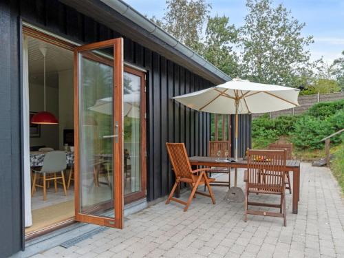 a patio with a table and an umbrella at Holiday Home Jonce - 250m from the sea in Sealand by Interhome in Vejby