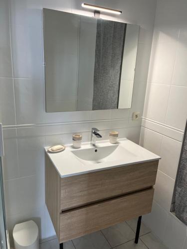 een badkamer met een wastafel en een spiegel bij Joli appartement in Cozes