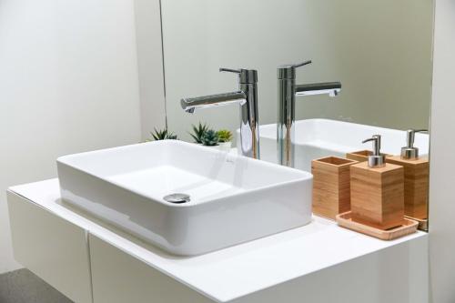 a bathroom with a white sink and a mirror at Apartment Rising Sun By Dalma Portuguesa in Armação de Pêra