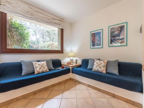 a living room with two blue couches and a window at Holiday Home Carlo-1 by Interhome in Villasimius