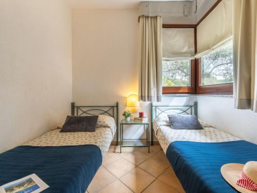 two beds in a room with a window at Holiday Home Carlo-1 by Interhome in Villasimius