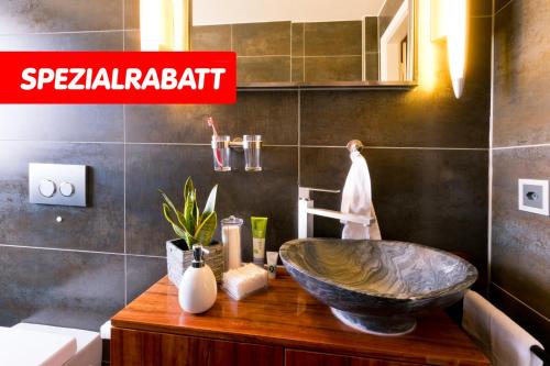 a bathroom with a large bowl sink on a wooden counter at Special Retreat Apartment & Home-Office & Workplace in Basel