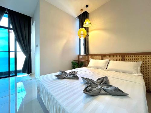 una camera da letto con un letto con due ciotole d'argento sopra di Covesign Suite a Kota Kinabalu