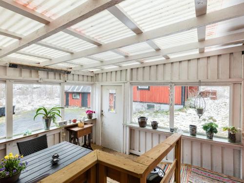 a screened in porch with a table and windows at Holiday Home Skjutsmåla by Interhome in Olofström