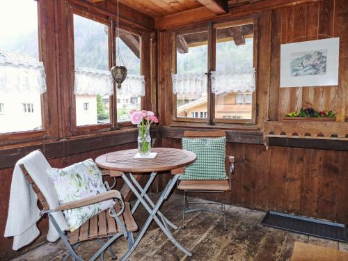 a table and chairs in a room with windows at Apartment Wellhorn by Interhome in Meiringen