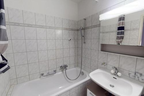 Baño blanco con bañera y lavamanos en Bright 1 bedroom flat in the city centre (Greenyard 2), en Zúrich