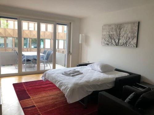 a bedroom with a bed and a living room at Bright 1 bedroom flat in the city centre (Greenyard 2) in Zurich