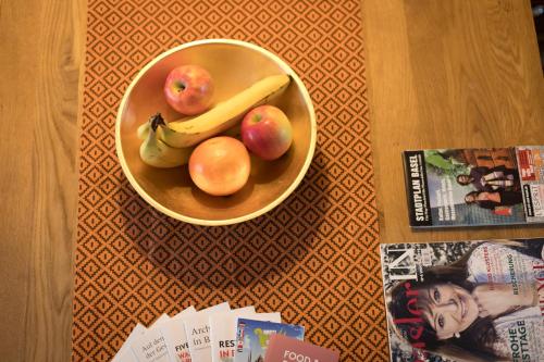 Special Retreat Apartment & Home-Office & Workplace في بازل: وعاء من الفواكه مع التفاح والموز على الطاولة