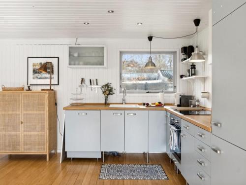 uma cozinha com armários brancos e um lavatório em Holiday Home Josef - 1-4km from the sea in Sealand by Interhome em Rørvig