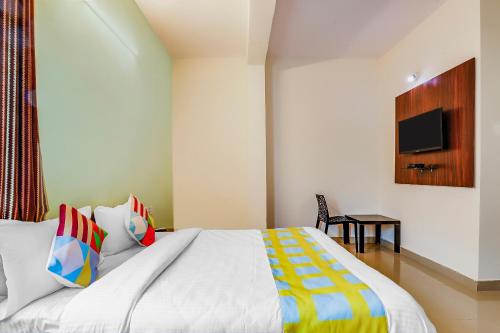 a bedroom with a bed and a tv on the wall at OYO Dream Connect Stays Near City Center Mall in Hyderabad